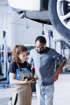 Woman shows client car checkup steps