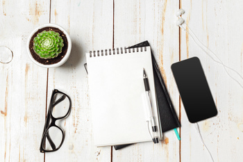 Succulent and Notebook paper in pot on table