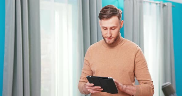 Smiling Man Using Cell Phone Computer on Moving Relocation Day Happy First Time Home Renter