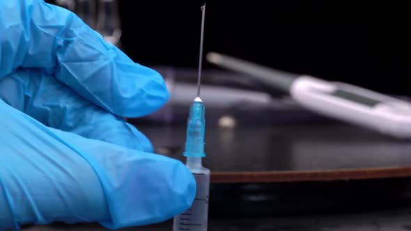 Nurse Prepares a Syringe And Medicine Drips From It in Large Drops Closeup