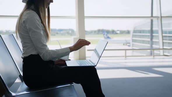 Young Pretty Woman Printing on Laptop Sitting at Airport