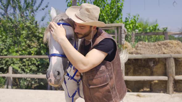 The man who takes care of his horse on the farm.