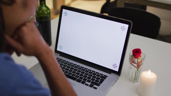 Mixed race man having a romantic dinner on video chat using laptop with copy space