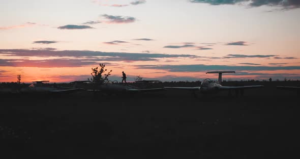 Distance View of the Silhouette of Boy Running Along Soviet Military Fighters and Another Boy