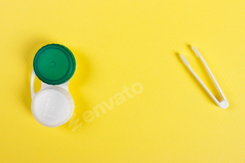 Accessories for contact lenses: container tweezers Yellow background