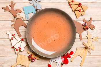 Top view of empty plate and New Year decorations on wooden background. New year