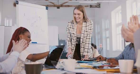 Beautiful Caucasian Female Team Leader Gives High Five To Happy African American Female Employee at