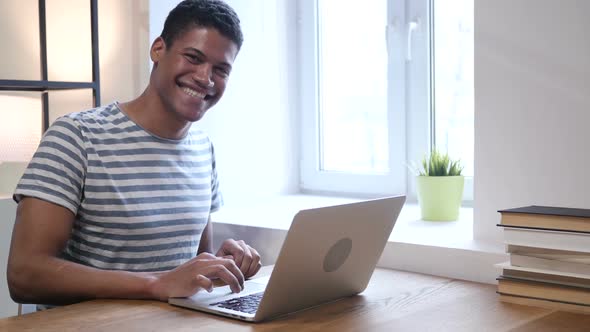 Black Man Smiling  toward Camera, Working in Office