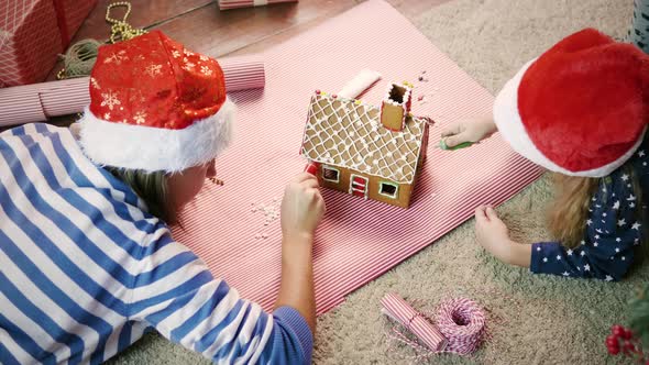 Family decorates gingerbread house 