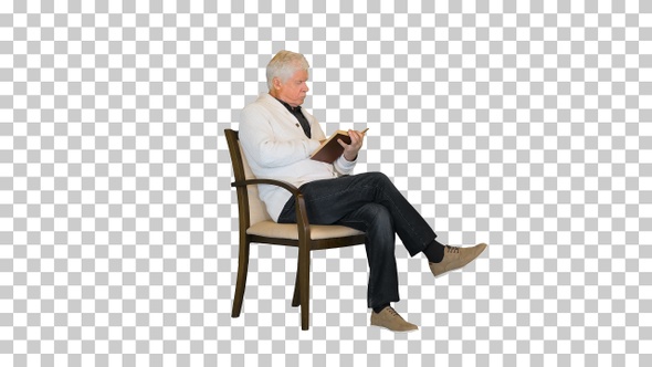 Senior man studying a book sitting in a chair, Alpha Channel