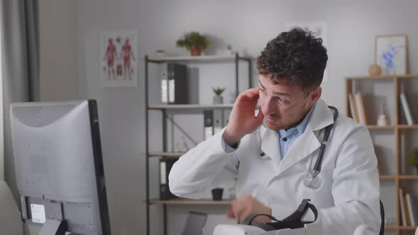 Tired Doctor Sits in Front of the Monitor and Massages His Face and Neck  Slow Motion Movie