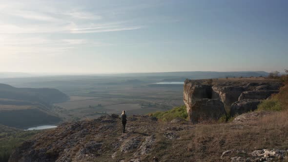 Woman reaching the edge of rock