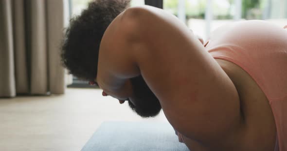 Video of plus size african american woman exercising at home