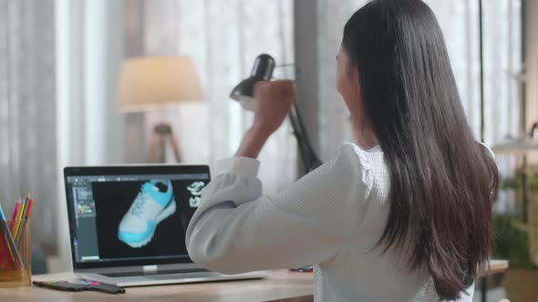 Asian Female Footwear Designer Celebrating Succeed Designing Shoe On A Laptop At Home