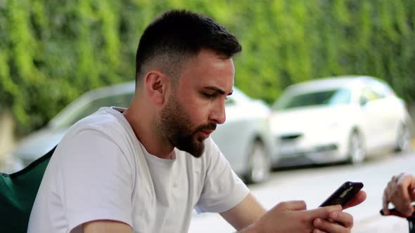 Bearded and handsome young man using mobile phone