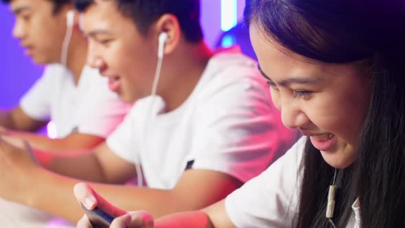 Close Up Team Of Asian Gamers Playing In Competitive Video Games By Mobile Phone