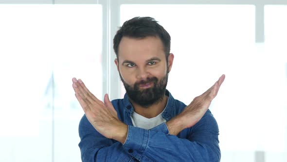 Man with Beard Rejecting Offer Sitting in Office