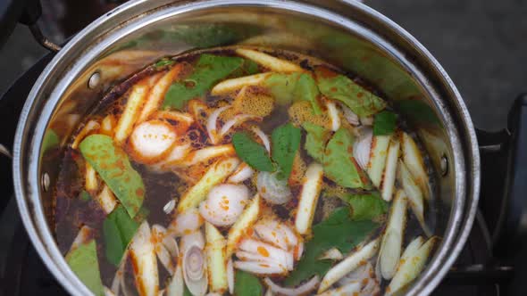 Looking into pot of Tom Yam soup that is starting to boil