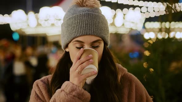 Portrait video of woman drinking hot chocolate on Christmas market