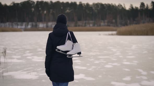 A Young Woman in a Dark Jacket, Came To the Frozen Lake To Go Ice Skating. In Winter, Nature Can Be