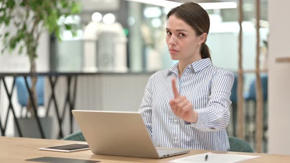 Serious Young Woman with Laptop Saying No By Head Shake 