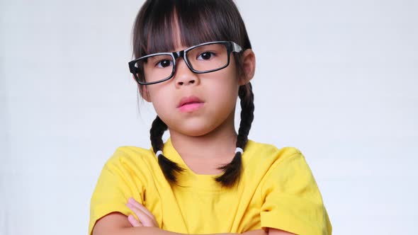 A school girl showing a trembling finger gesture saying no on white studio background.