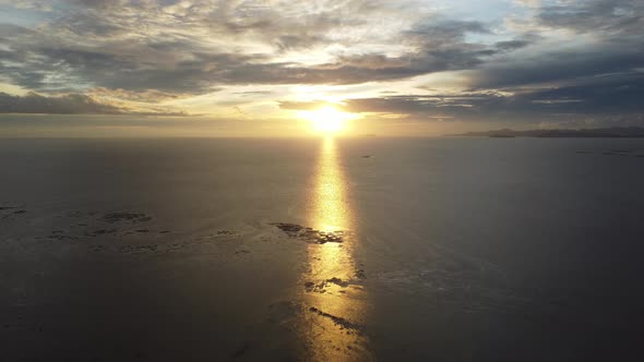 Aerial fly backward during dramatic sunset hour