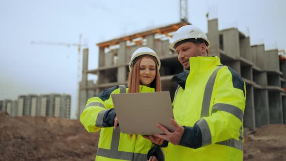 Foreman and Female Architect are Discussing Project and Progress of Construction of Modern Building