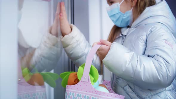 Tilt up video of little girl in protective mask showing Easter basket.