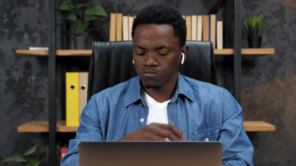 Thoughtful African American Man Works for Laptop and Thinks in Office