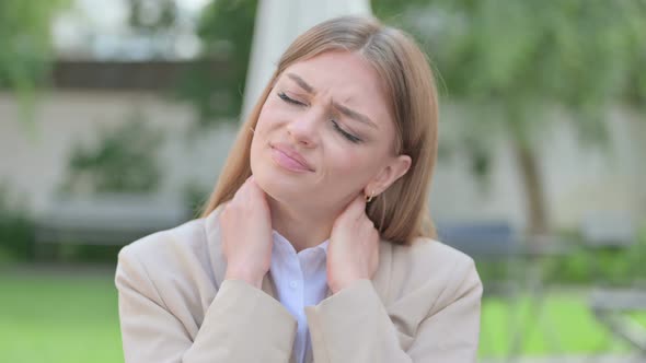 Outdoor Portrait of Young Businesswoman Having Neck Pain