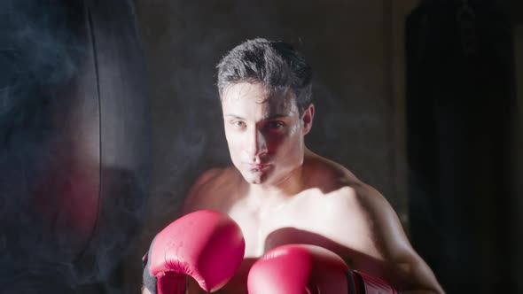 Young Male Boxer Stepping Out From the Dark Background