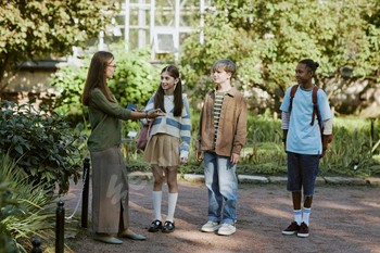 Tour Guide Greeting Kids In Botanical Garden