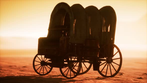 Canvas Covered Retro Wagon in Desert at Sunset