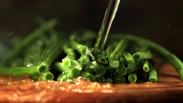 Super Slow Motion Jet of Water Pours Onto the Green Onion