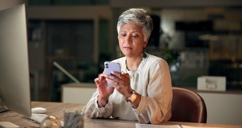 Phone, read and mature businesswoman in office at night with communication, networking and contact.