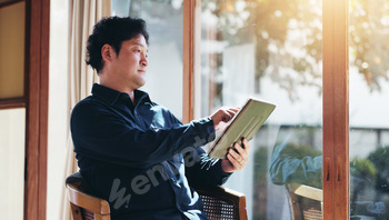 Japanese, man and home with tablet for connection, search online and reading ebook with technology.