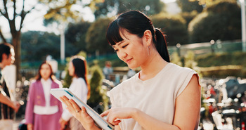 Japanese woman, city and smile with tablet for online networking, reading ebook or travel location