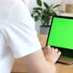 Over the shoulder shot of a man typing on a computer laptop with a key-green screen - VideoHive Item for Sale