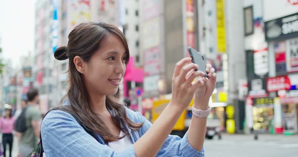 Backpacker woman visit Tokyo city, take photo on cellphone