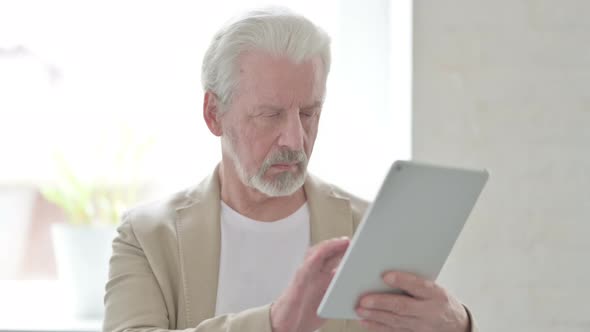 Old Man Using Internet on Digital Tablet