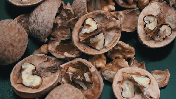 Lot of Walnuts in the Shell are Spinning on a Black Background