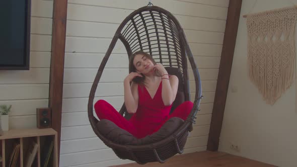 Pretty Elegant Female Relaxing in Hanging Chair