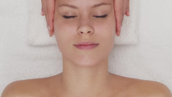 Young, healthy and beautiful woman gets massage therapy in the spa salon.