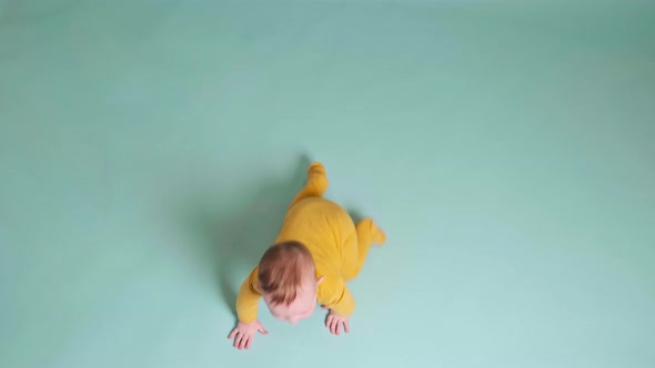 Happy toddler baby plays laughing on studio blue background. Funny child boy