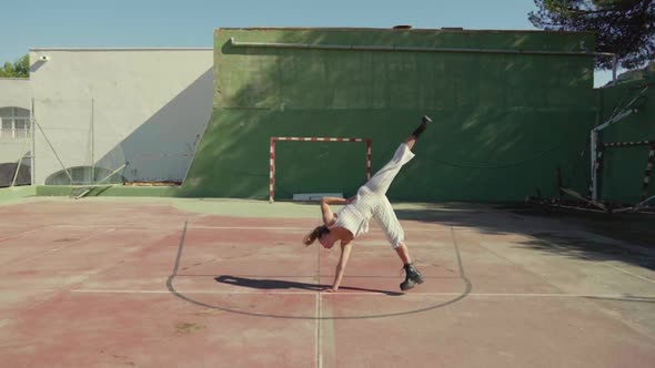 Slow motion shot of young woman turning cartwheel on soccer ground