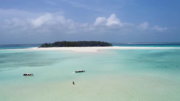 Touristic boats anchoring in shallow tropical waters of Mnemba atoll.