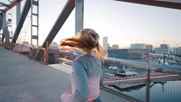 Pretty Athletic Millennial Woman Street Runner Jogging Along Harbor Bridge