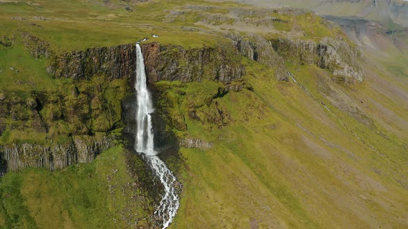 Aerial Drone Footage of Bjarnarfoss Waterfall with Its Green Cliffs in Western Iceland