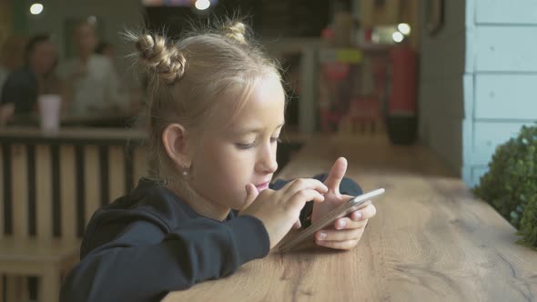 Happy Child Girl Look Smart Phone. Little Girl Play Mobile Phone. Education, School, Technology